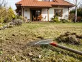 Grabie leżą na trawniku po wertykulacji. Czas pomyśleć, jak często nawozić trawnik, by był piękny.